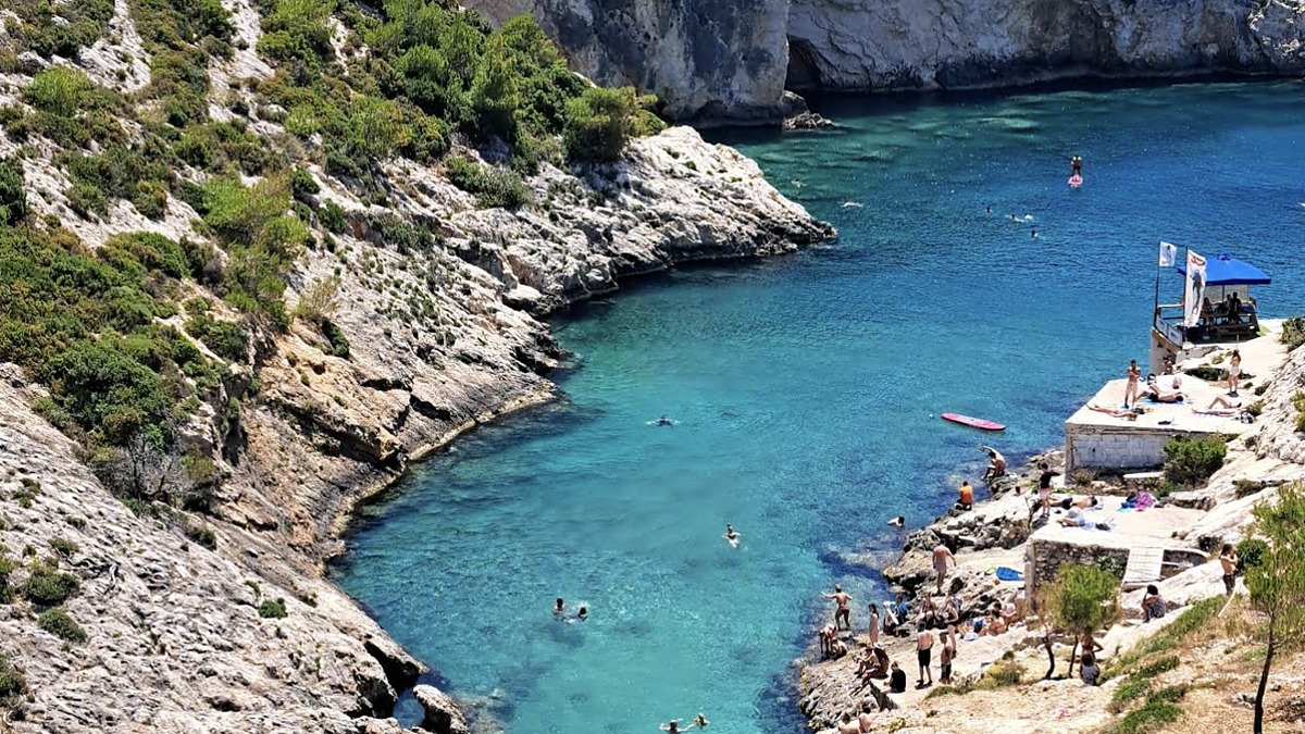 Porto Limnionas on the west coast of Zakynthos, a deep-blue rocky inlet framed by limestone cliffs