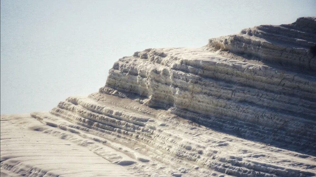 Close-up of the soft, chalky white marl of Scala dei Turchi, worn into smooth stepped layers, the rock that erodes and crumbles under foot traffic