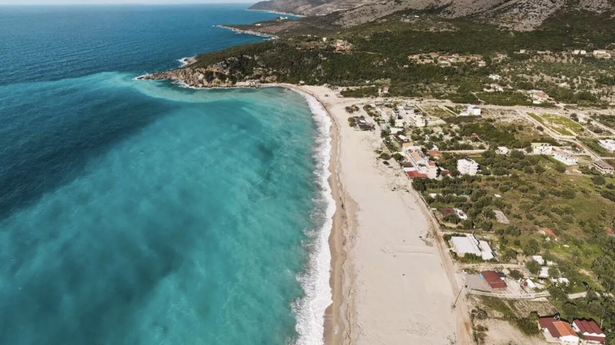 The wide open bay at Livadhi near Himare on the Albanian Riviera, a long sweep of sand and pebble backed by green hills