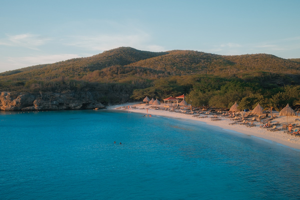 Secluded tropical beach with turquoise water and green hills in the background