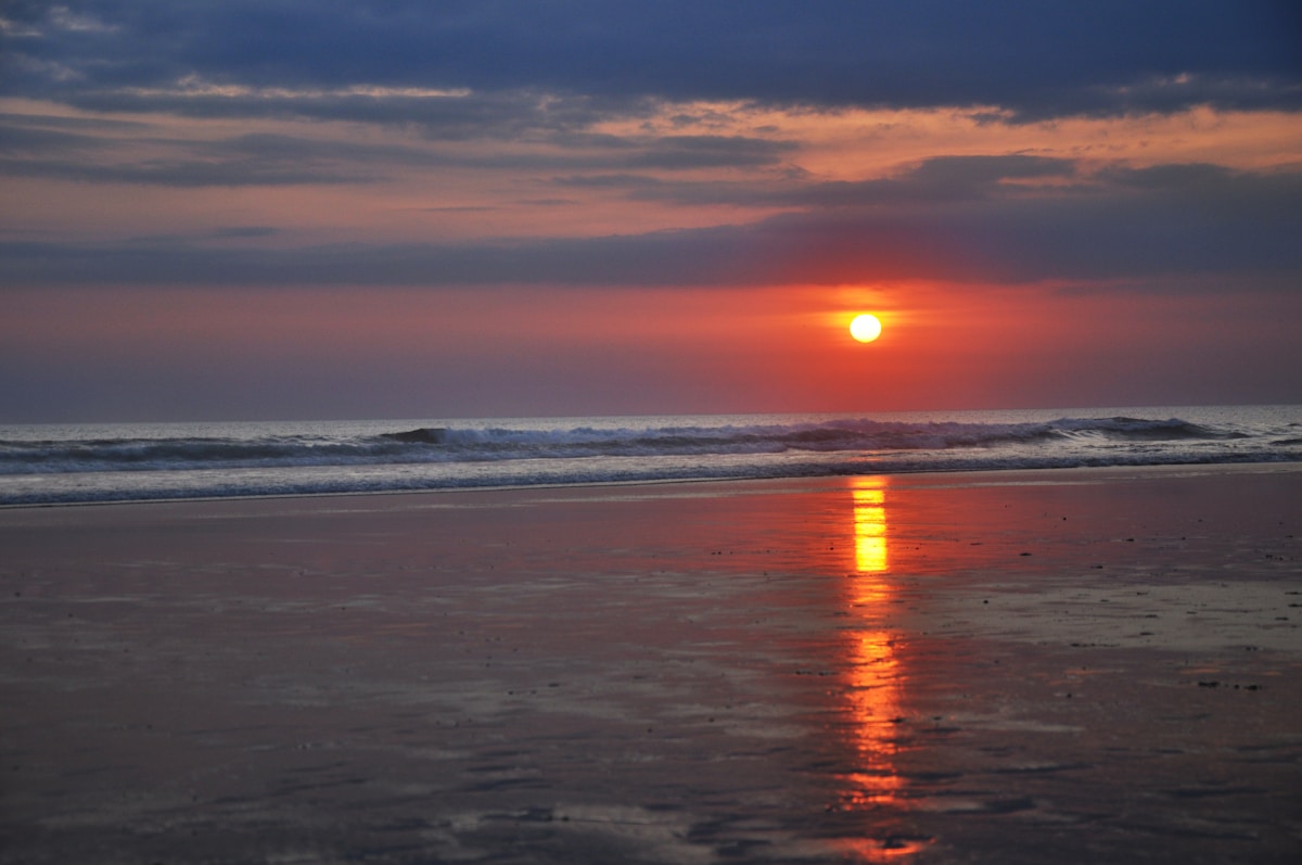 Beach clubs along Seminyak shore with sun loungers and umbrellas at sunset