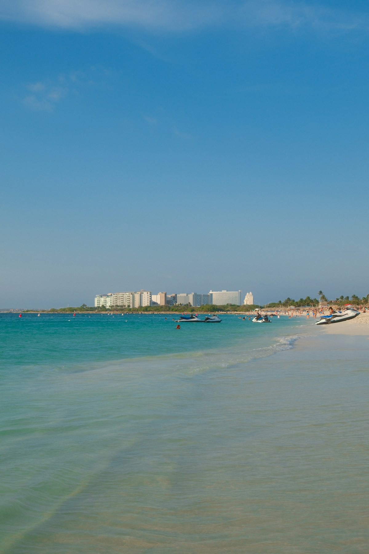 Resort beach with white sand and calm turquoise water on a sunny day in the Canary Islands