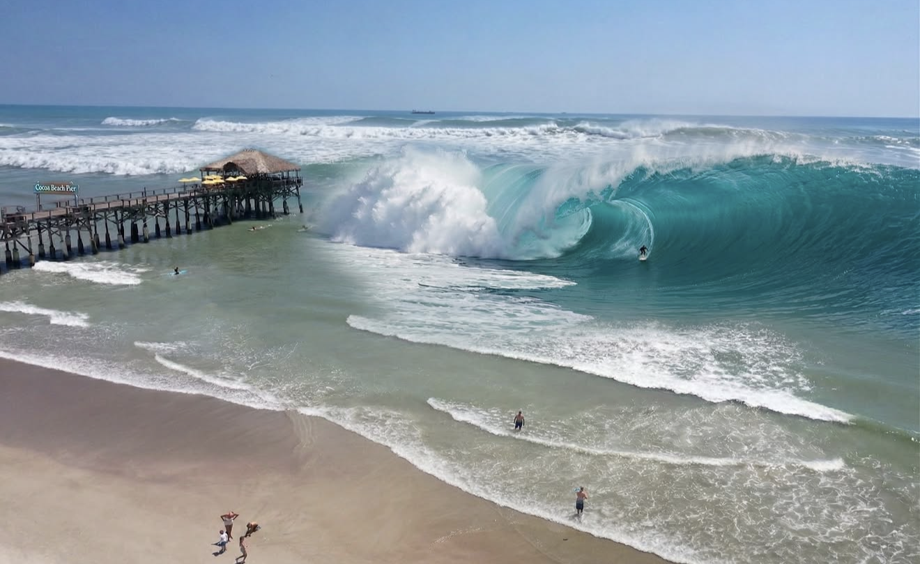 Cocoa Beach Pier extending into the Atlantic with surfers in the water