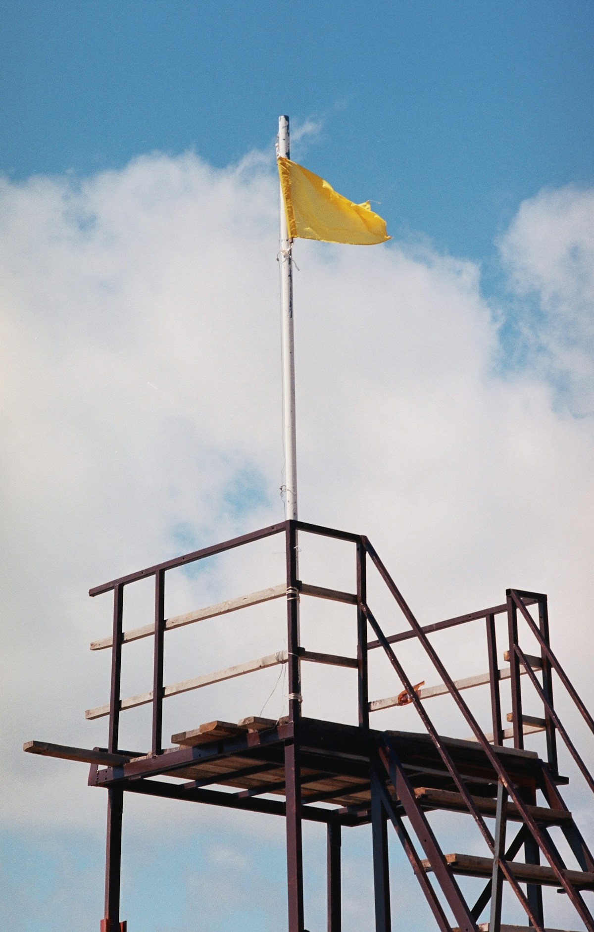Yellow caution flag flying on a lifeguard stand at the beach